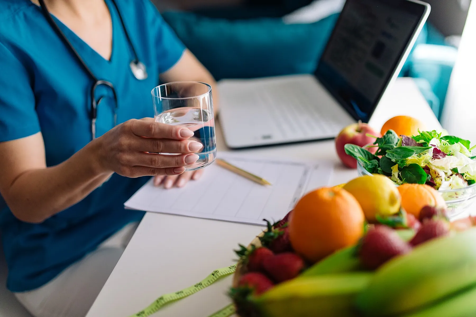 Vårdpersonal i samtal, med ett glas vatten och frukt på bordet